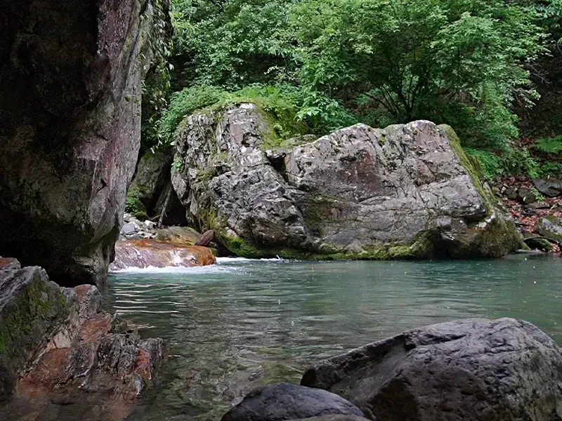 Mini Thailand Jibhi rock pool surrounded by boulders and trees